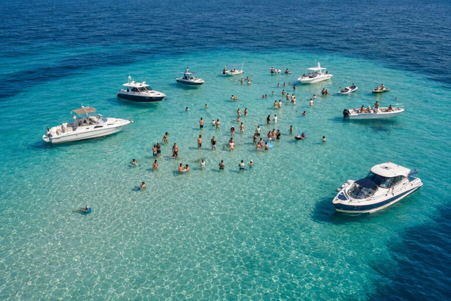 Boats and guests enjoying a clear-water sandbar